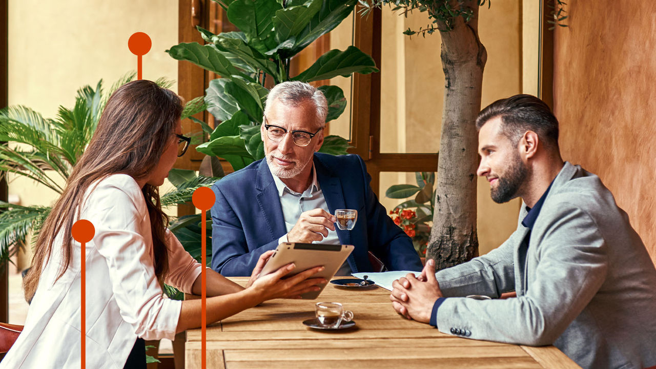 Business lunch. Three people in the restaurant sitting at table drinking hot coffee woman showing creative ideas on digital tablet. Team work concept