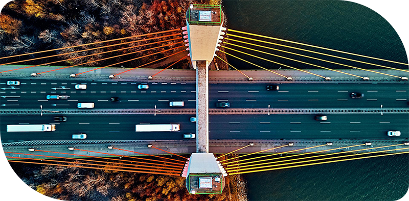 Beautiful panoramic aerial drone view to cable-stayed Siekierkowski Bridge over the Vistula river and Warsaw City skyscrapers, Poland in gold red autumn colors in November evening at sunset - top down